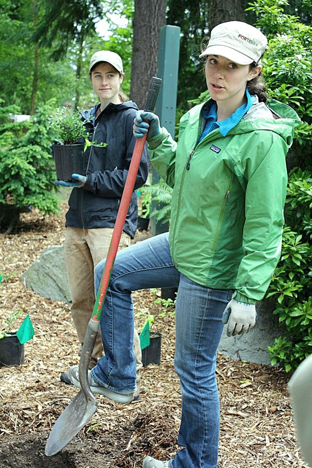 Norah Kates (left) and Katie Cava from Forterra demonstrate planting techniques during a Green Kirkland Partnership training event on June 9.