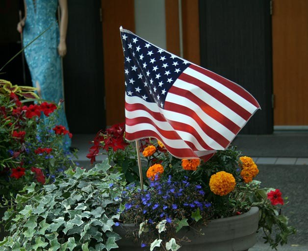 Remembering 9/11: A stick flag sways in one of several flower pots along Lake Street to commemorate the 10th anniversary of 9/11. About 15 volunteers put out nearly 3