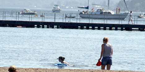 Swimmers take advantage of the hot weather on Thursday afternoon with a dip in the Juanita Beach swimming area