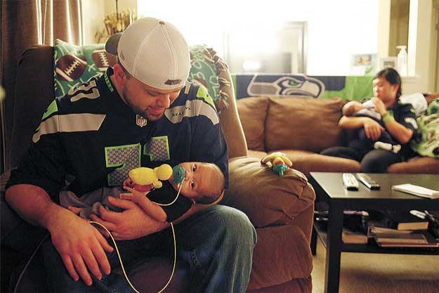 Dave and Kristina Quick hold their 8-week-old twins Franklin (left) and Harrison at their home in Brier. Complications with Franklin’s health when the twins were born led to an extended stay at Seattle Children’s Hospital.