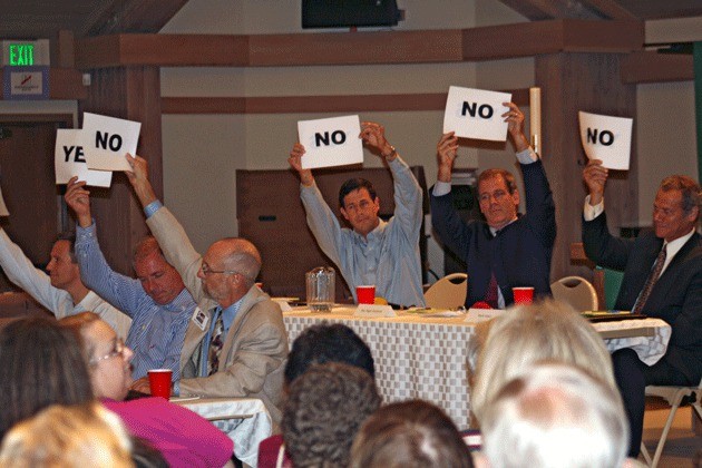 45th District candidates hold up 'yes' or 'no' signs in response to 'lightning round' questions during a forum at Holy Spirit Lutheran Church in Kirkland Tuesday.