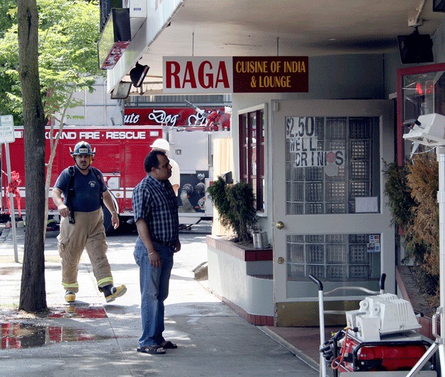 Mukesh Kakar looks into the front door of his restaurant