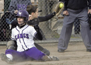 Lake Washington’s Nicole Spangler slides safely into home for a two-run homerun in the first inning of a 6-4 win over Redmond April 9 at Crestwoods Park.