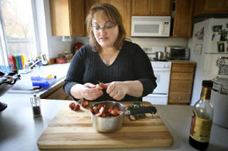 Lisa Hubbell cuts up strawberries for a Balsamic Strawberry Compote in her Kirkland kitchen. Hubbell