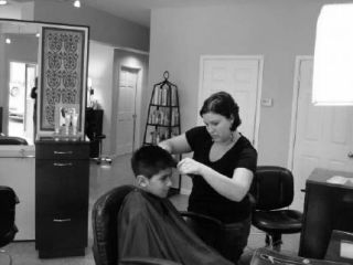 Bella Sirena Boutique Salon stylist Shelby Giovannini cuts a boy’s hair June 1 during the salon’s “day of pampering” for Family Village residents.