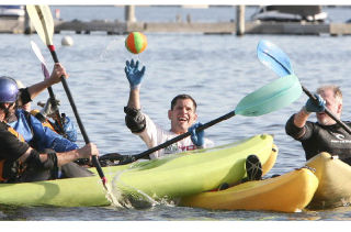 Kayaks gently collide and paddles go up in defense as Scott Koerner