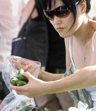 Jin Kang selects peppers from the Magana Farms booth during a visit to the Wednesday Market on Aug.