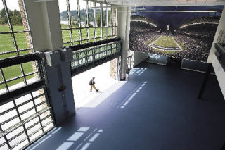 The view from a loft designated for a cardio workout space. The outdoor playing field is viewed through windows at left