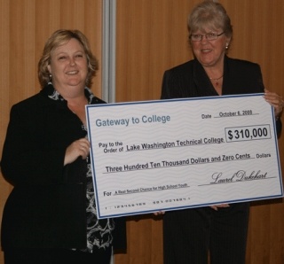 LWTC president Sharon McGavick receives a check from Gateway to College executive director Laurel Dukehart.