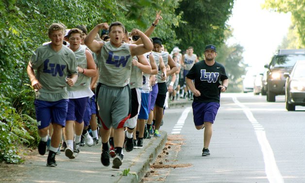 The Lake Washington High School football team takes a run from the high school gymnasium to Tech City Bowl for a day of bowling and bonding during the preseason.