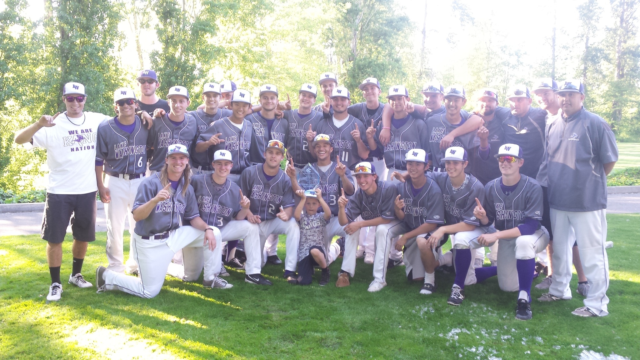 The Lake Washington High baseball team poses with the KingCo 3A tournament trophy outside Bannerwood Ballpark on Tuesday