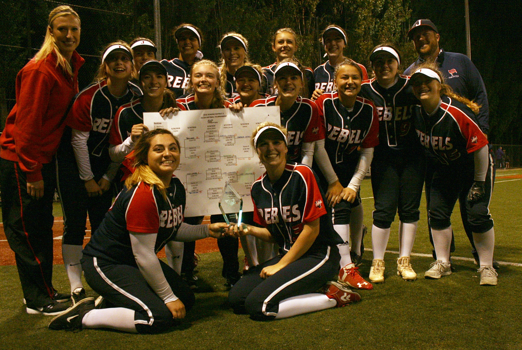 The Juanita High softball team poses together with the 2016 SeaKing District II bracket and tournament trophy after beating Lake Washington 5-1 for the tournament title on Friday