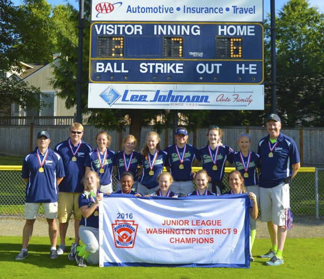 The Kirkland Junior Softball All-Star team stands with the District 9 championship banner after beating Bellevue in the district title game