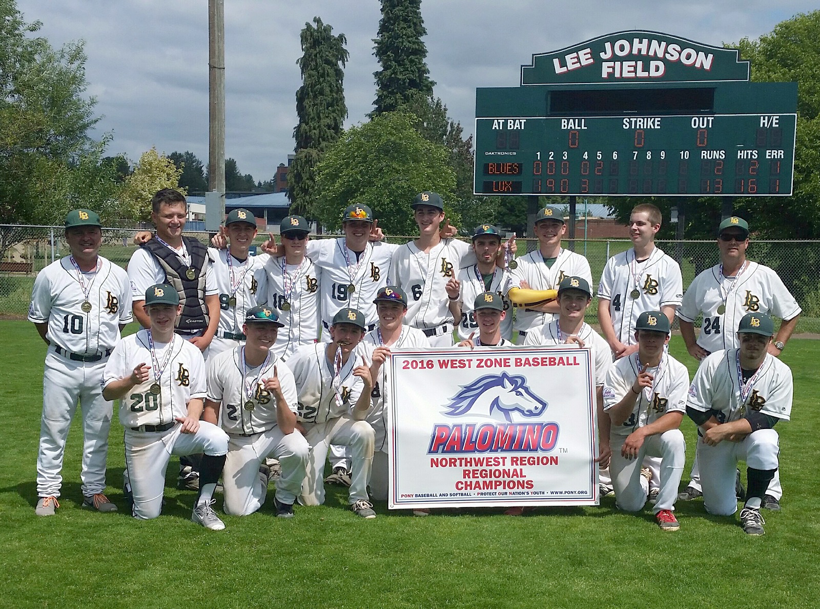 The Kirkland Lux Baseball team stands with the Palomino Northwest Regional championship banner on Sunday