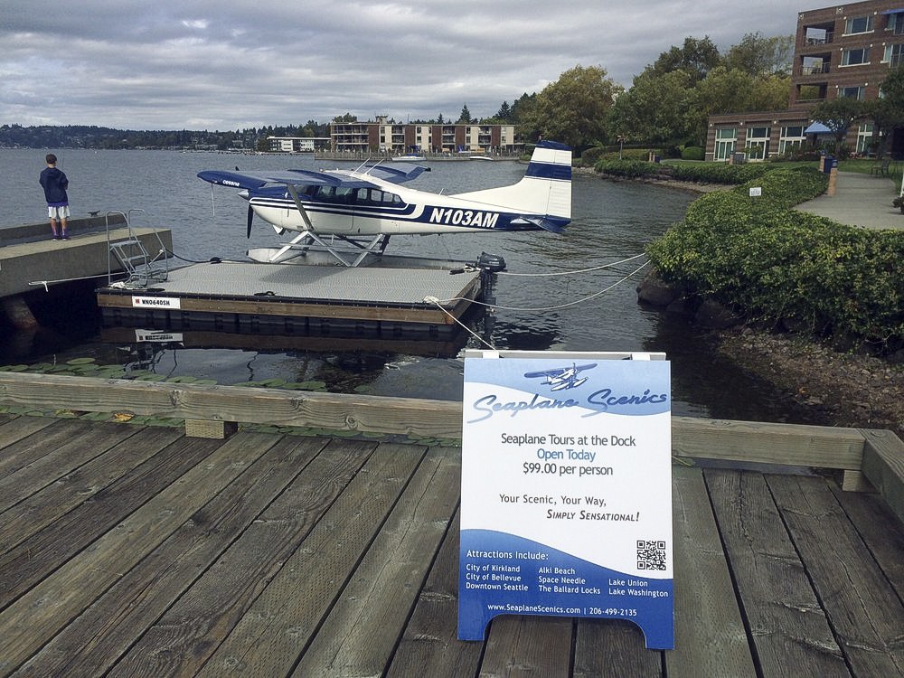 A seaplane sits moored at the guest pier in front of the Woodmark Hotel at Carillon Point