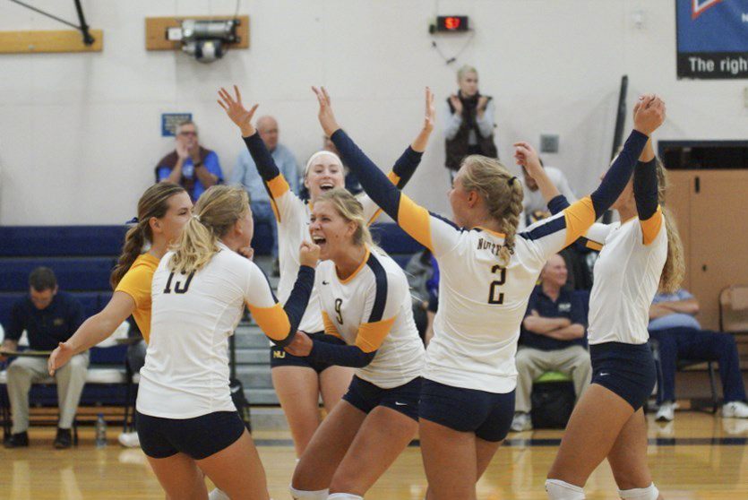 The Northwest University volleyball team celebrates during a home match earlier this season. The Eagles have risen into the NAIA top-25 in the last several weeks