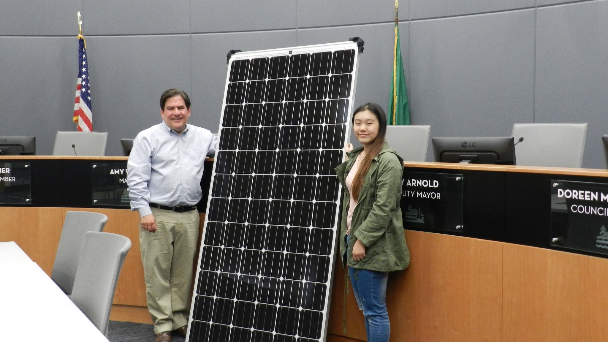 Kirkland Deputy Mayor Jay Arnold and International Community School student Allison Li pose with one of the solar panels to be installed at Kirkland City Hall. Image Credit: City of Kirkland