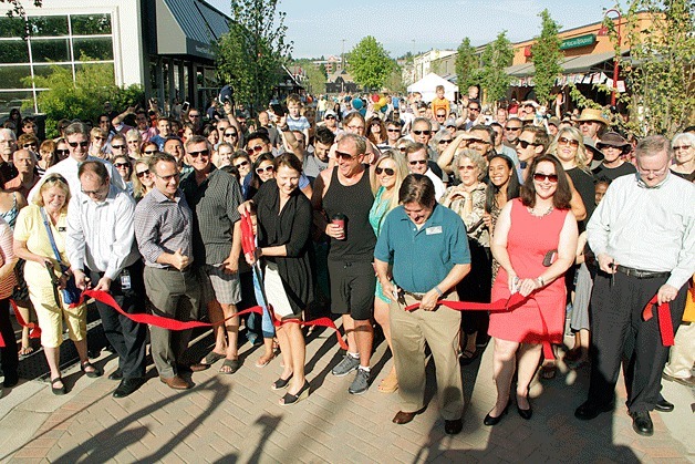 Members of the Kirkland City Council help with the Park Lane ribbon cutting ceremony on May 29 as residents look on during the celebration.