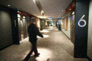 A server carries a tray of dessert down the hallway during a screening for friends and family at Village Roadshow Gold Class Cinemas on Oct. 24.