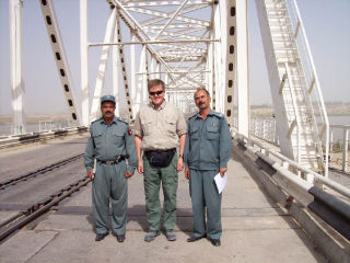 Juha Salin stands with border police chiefs at the “Peace Bridge” from Afghanistan to Uzbekistan. It is the same bridge used by the Soviet Union to invade Afghanistan in 1979 and exit in 1989.