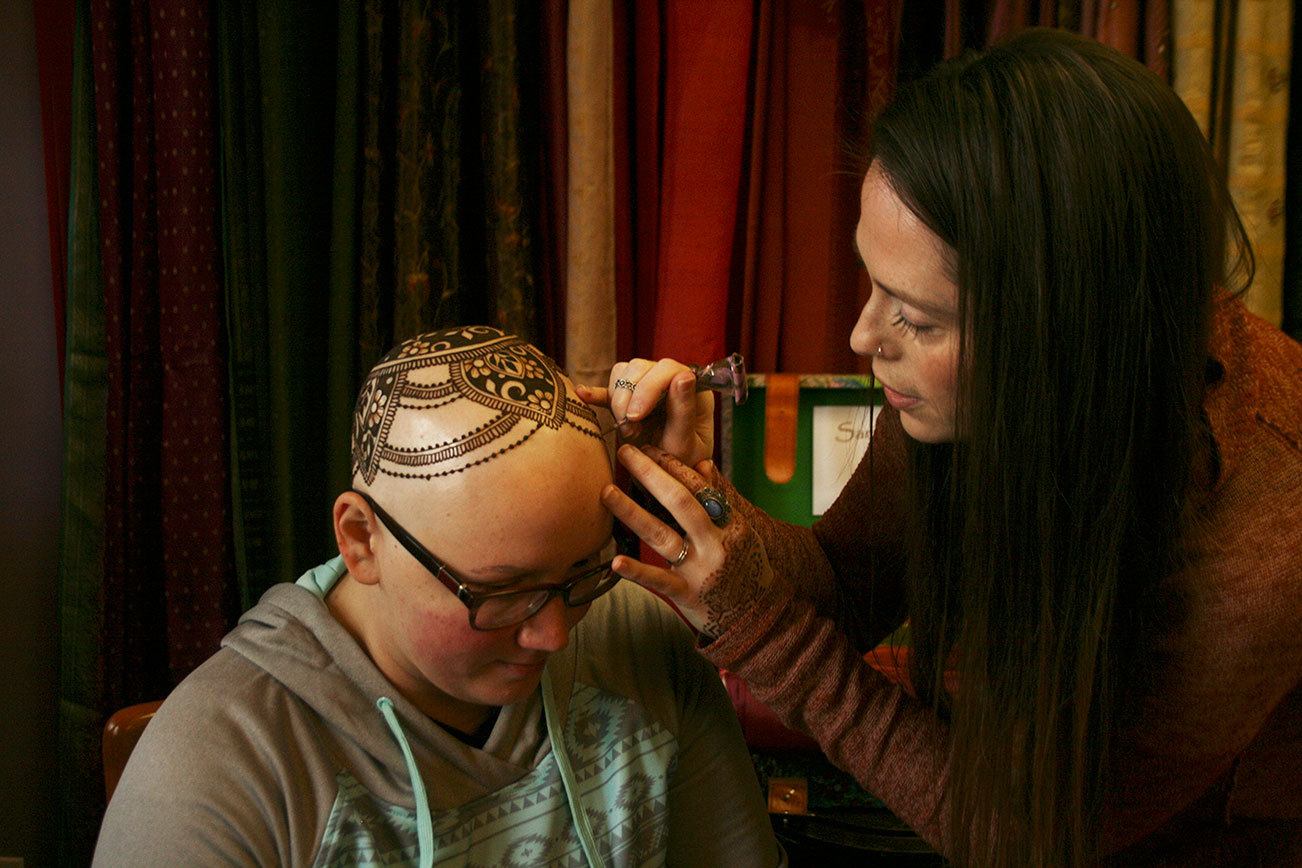 Kirkland artist Sarah Walters creates a henna crown for Mary Glasco at Sankara Imports in Bothell. CATHERINE KRUMMEY/Kirkland Reporter