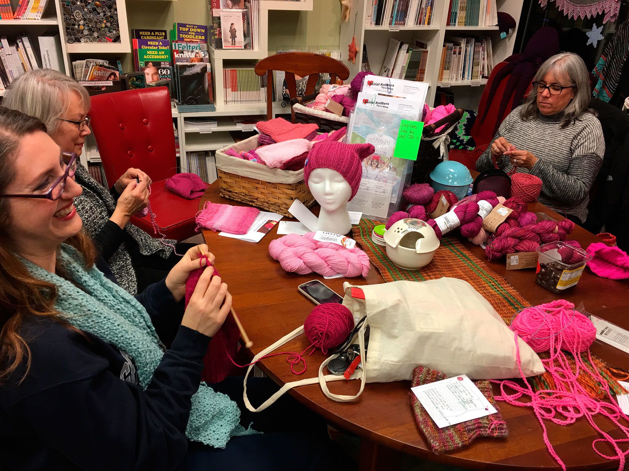 Jennifer Cail (left), Susanna Gilbert and Sabrina Barton participate in a Pussyhat Project event at Serial Knitters in Kirkland. Contributed photo