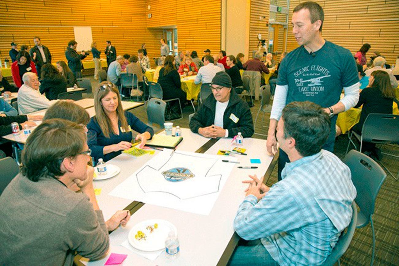 Peter Kageyama (standing at right) discusses a T-shirt design with Kenmore residents at a “For the Love of Kenmore” event in 2015. Kageyama will host a workshop at “For the Love of Kirkland” on Jan. 23. Reporter file photo