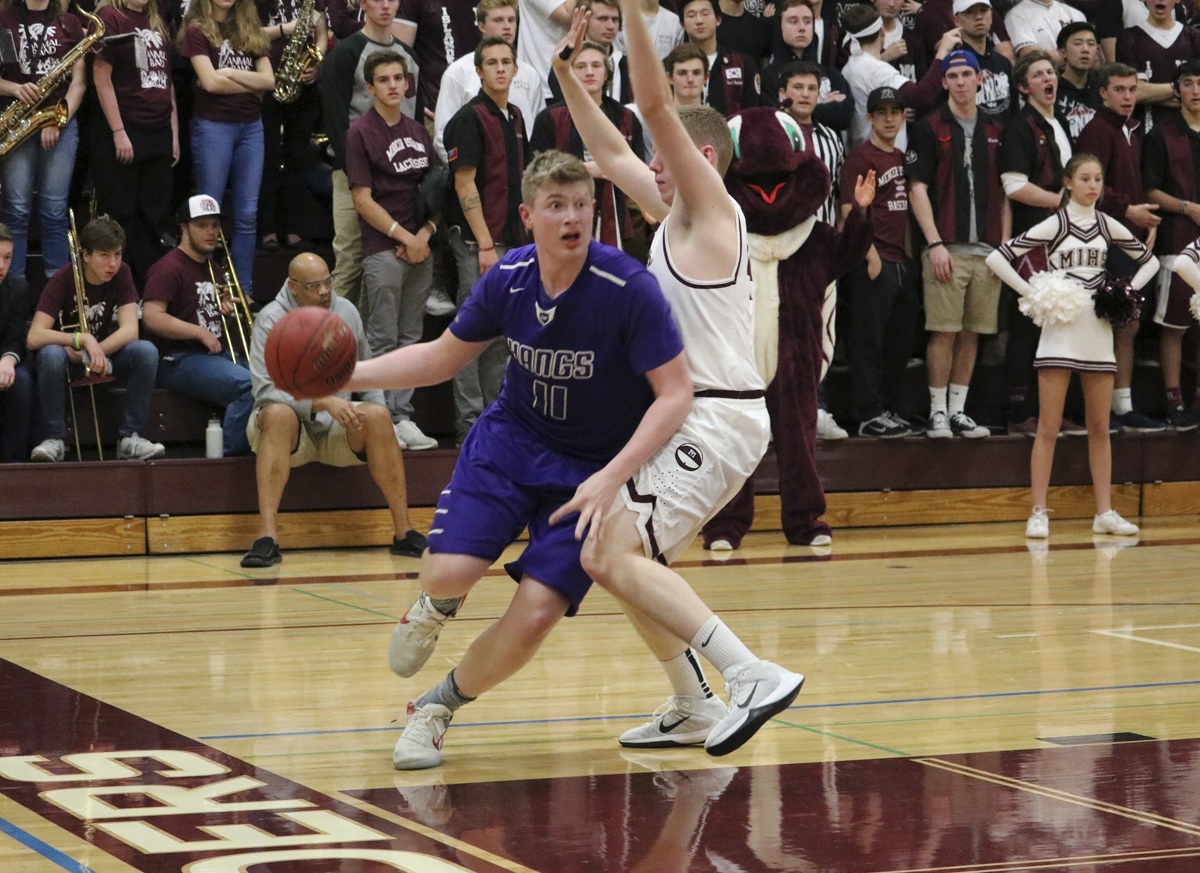 Lake Washington’s Griffin Barker drives past Mercer Island’s Jacob Evans Tuesday at Mercer Island High School. The Kangs beat the Islanders 48-42. Joe Livarchik/Mercer Island Reporter