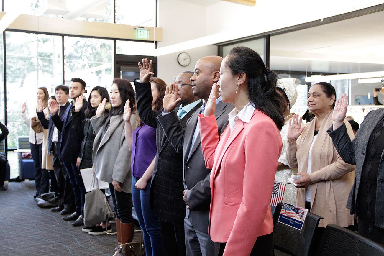 Local immigrants take the Oath of Allegiance to become U.S. citizens during a naturalization ceremony at the Kingsgate Library. KATHY CUMMINGS/Contributed photo
