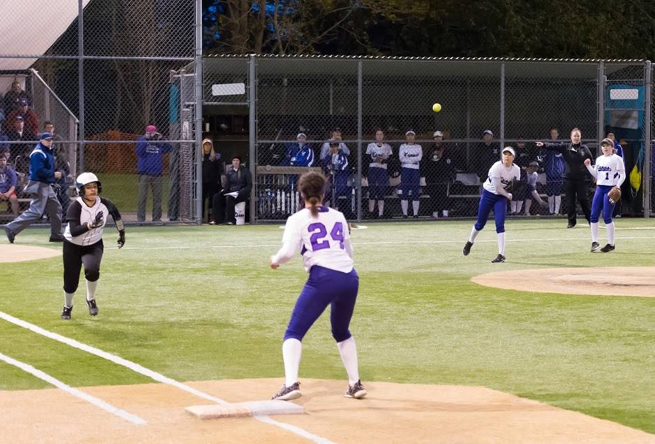 Lake Washington pitcher Tori Bivens fields a grounder and throws out Redmond’s Lindsay Tsujikawa at first. Courtesy of Eric Chen