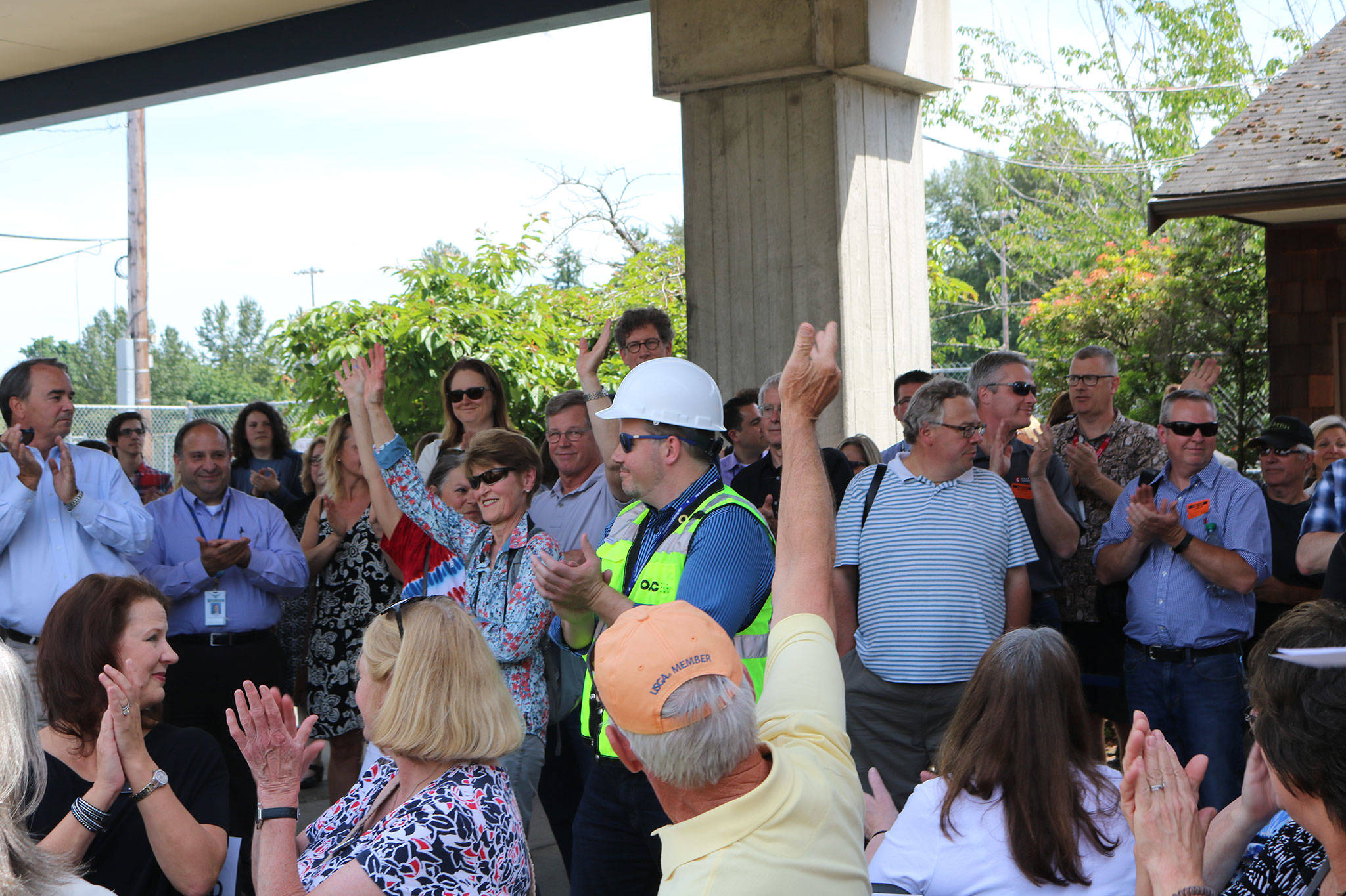 Dozens of people attend the groundbreaking ceremony. They were asked to raise their hands if they’re Juanita High School graduates. CATHERINE KRUMMEY / Kirkland Reporter