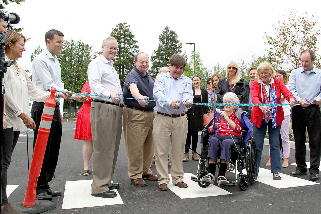 Kirkland City Councilmember Doreen Marchione (center, with the big scissors) cuts the ribbon at the new parking lot in downtown Kirkland alongside fellow councilmembers, city staff and representatives of the Kirkland Downtown Association and Greater Kirkland Chamber of Commerce. Photos courtesy of the City of Kirkland