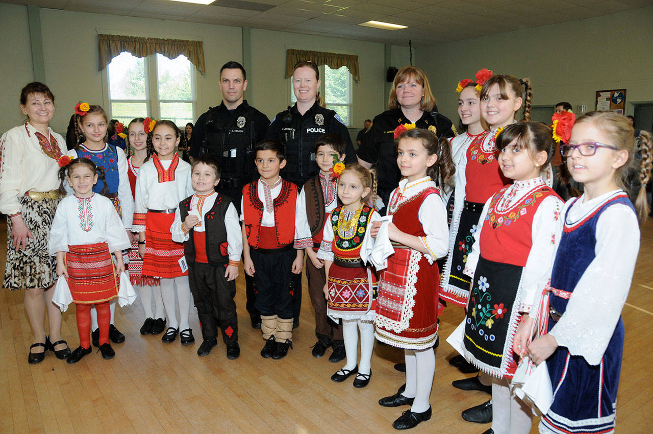 Hopatropa, a children’s folk dance group from Bulgaria, stand with Kirkland police during a “Welcome to Juanita” event in Kirkland. Photo courtesy of Doug Rough