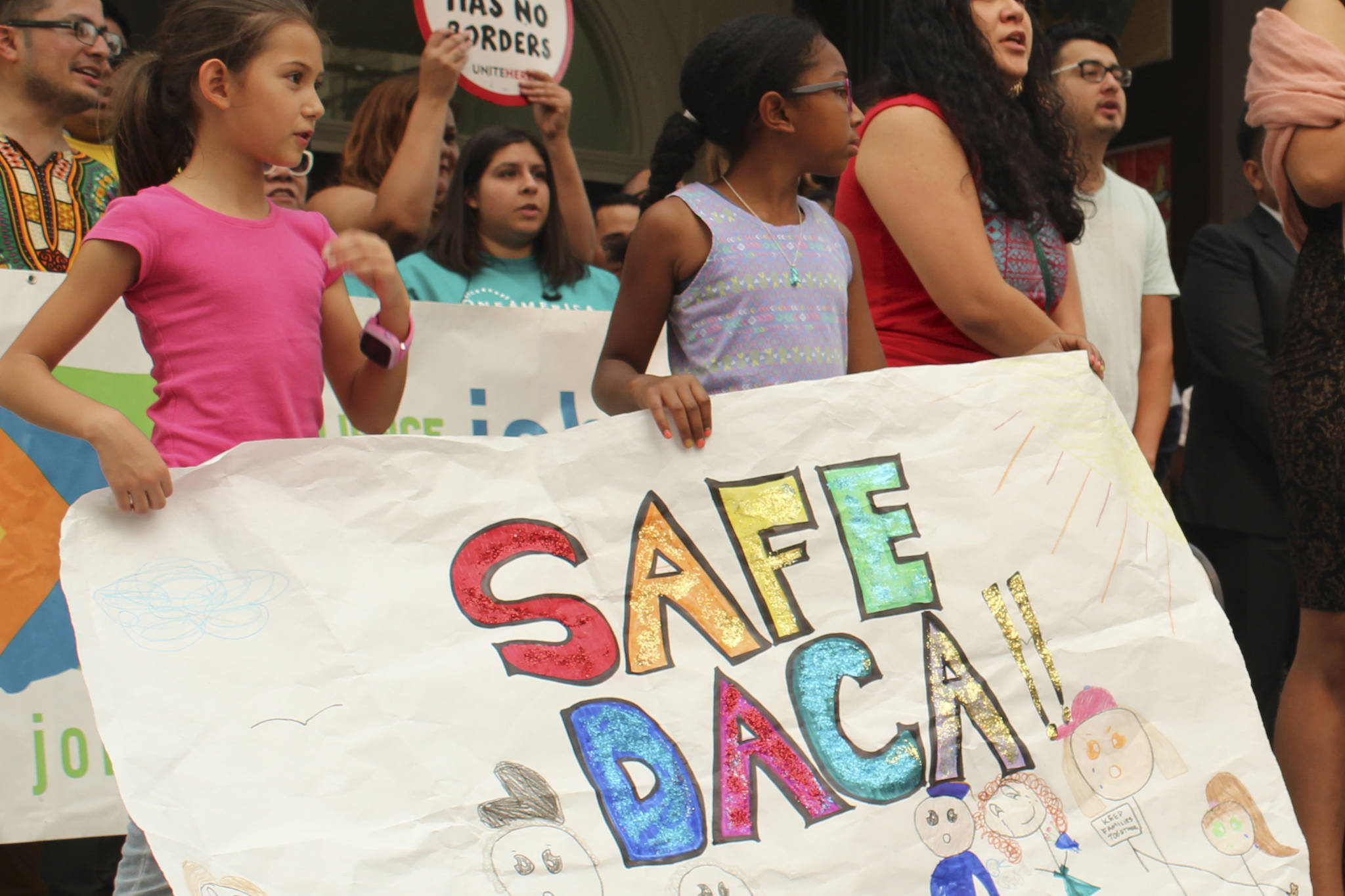 Kids hold a sign at a DACA support rally on September 5. Photo by Sara Bernard
