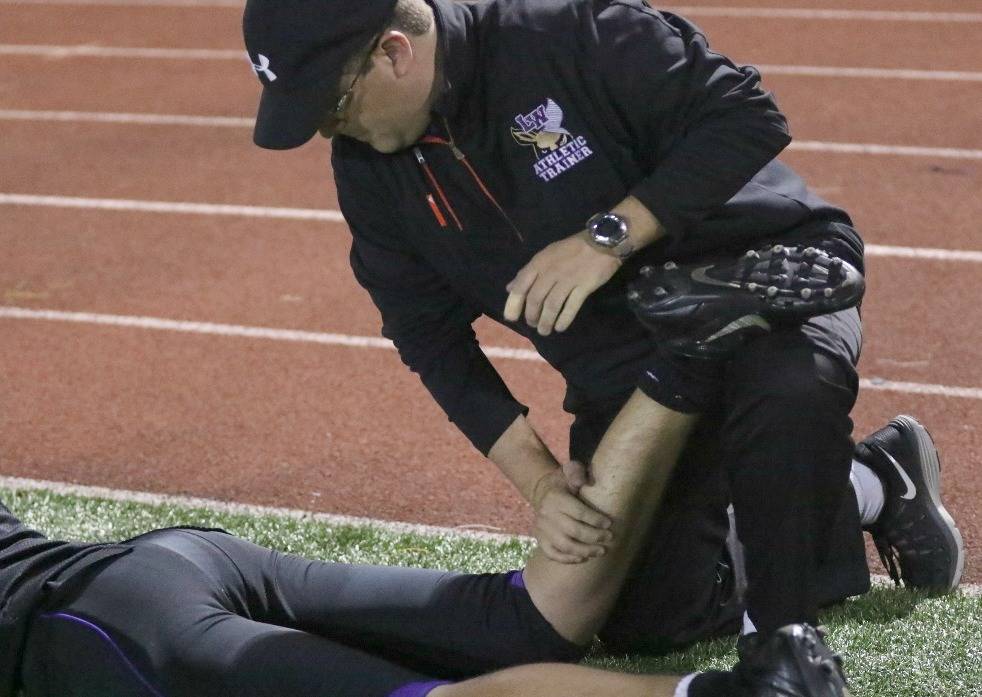Lake Washington High School athletic trainer Delaney Farmer attends to a football player. Courtesy of the Lake Washington School District