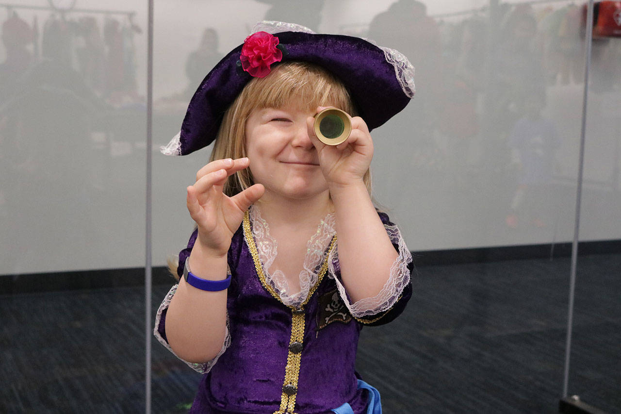 Hailee Lewbel, 3, dressed like a pirate, looks through a looking glass during the costume swap Saturday. Megan Campbell/Kirkland Reporter