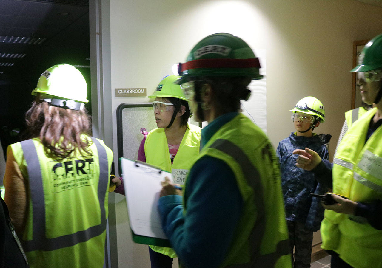 Lani Alvarez, the incident commander during a CERT search and rescue drill, instructs teams of two to enter a dark building. Megan Campbell/Kirkland Reporter