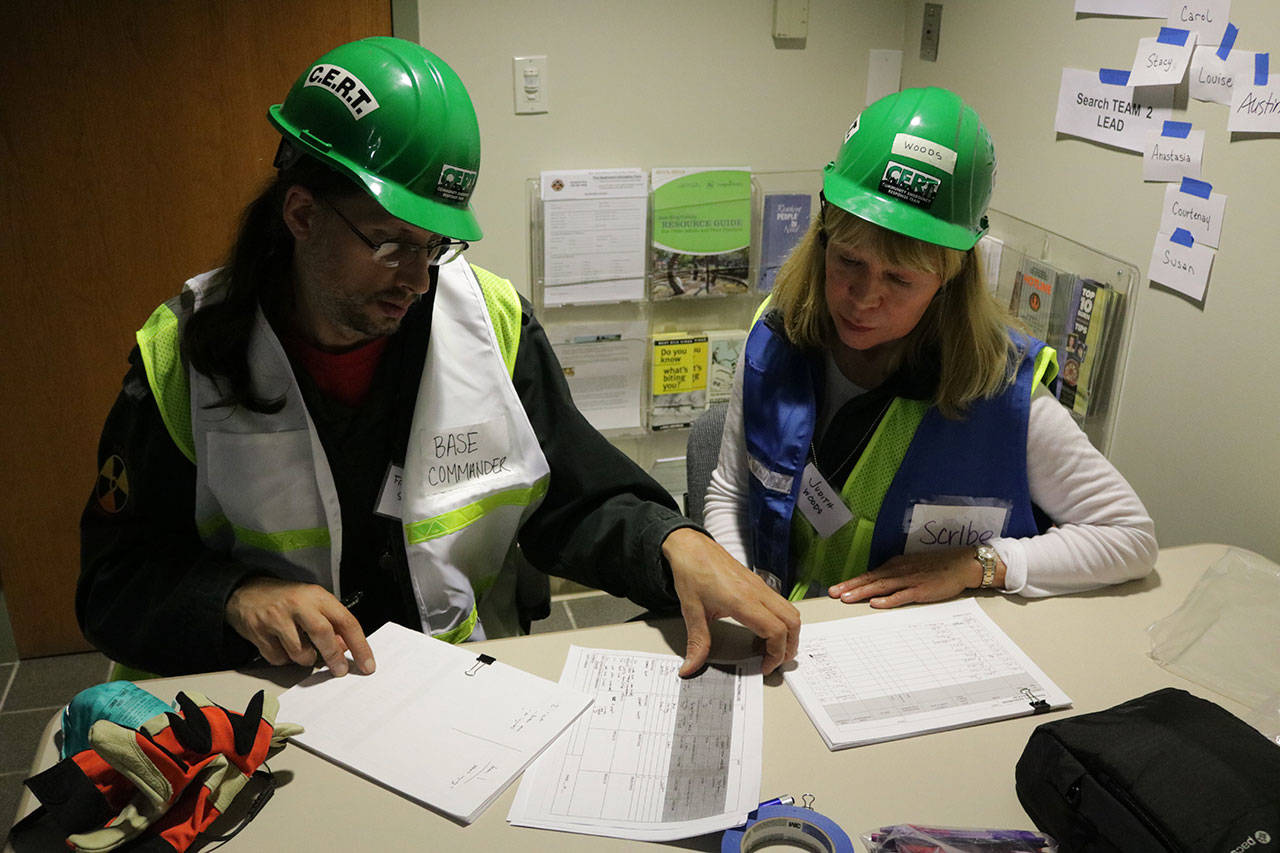 Base commander Frank Sanborn and scribe Judith Woods document what the CERT teams find during a training exercise. Megan Campbell/Kirkland Reporter