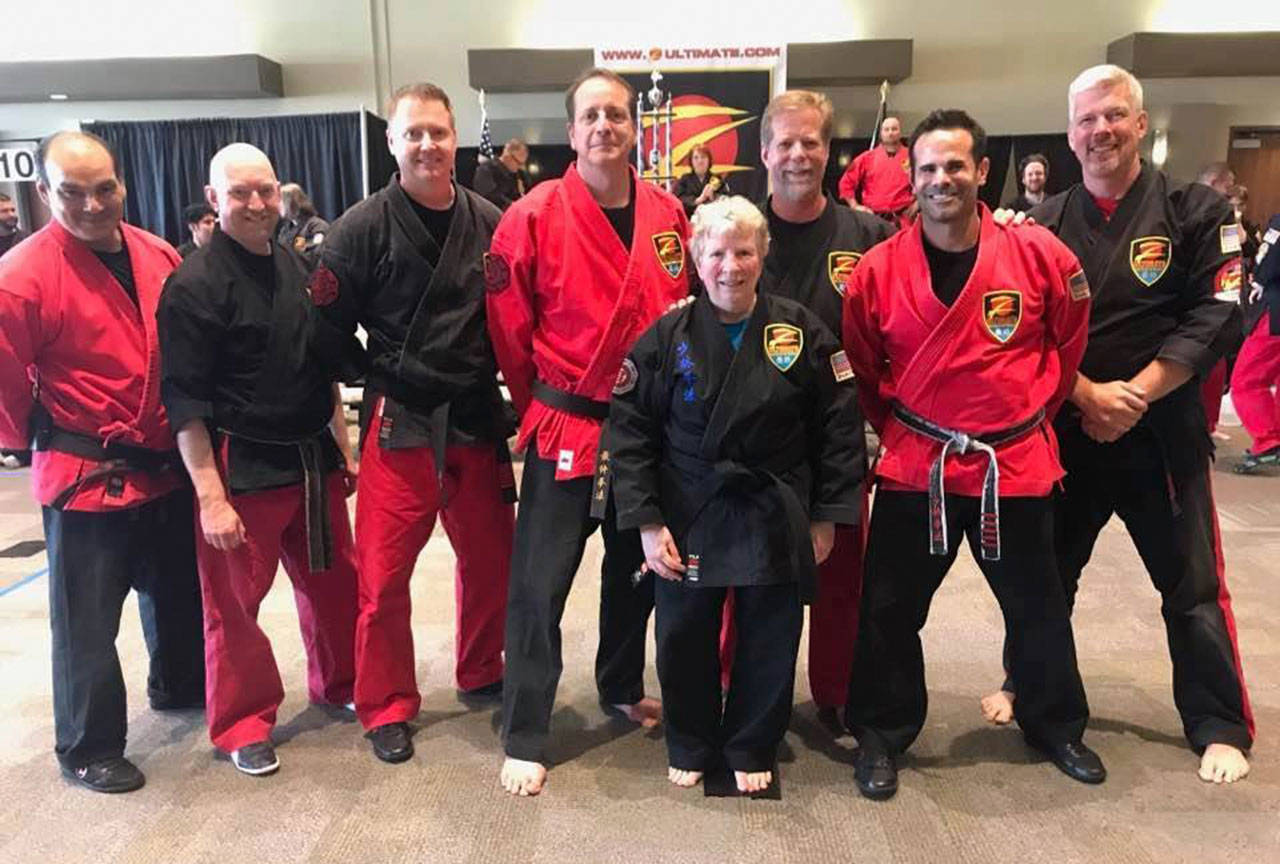 Sensei Claire Sullivan, center, poses for a photo with, from left to right, Master Diaz (5th degree black belt), Master Thomas (5th degree black belt), Master Prosch (7th degree black belt), Shihan Ley (8th degree black belt), Master Ezlinger (7th degree black belt), Master Ducati (5th degree black belt) and Master Brookman (6th degree black belt) during the Z-Ultimate Self Defense Studios tournament in Everett in September. Courtesy of Z-Ultimate Self Defense Studios Kirkland