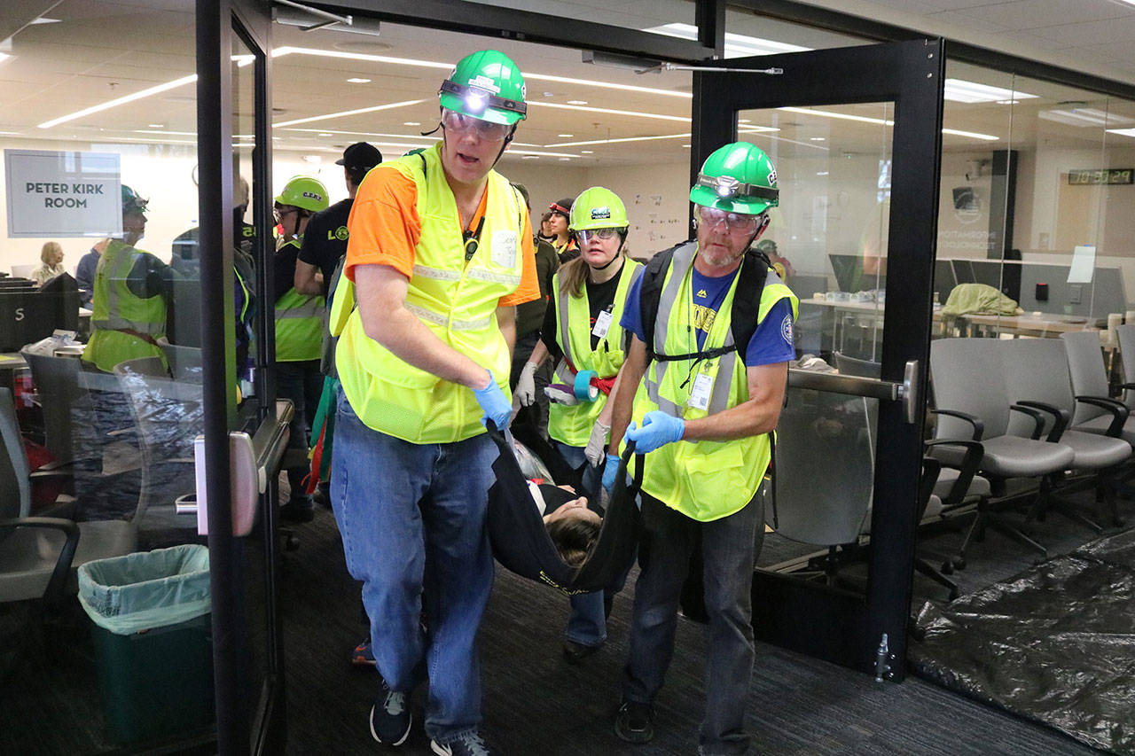 CERT members carry a survivor of a major earthquake to the medical area during a disaster drill in Kirkland City Hall Nov. 18. Megan Campbell, Kirkland Reporter