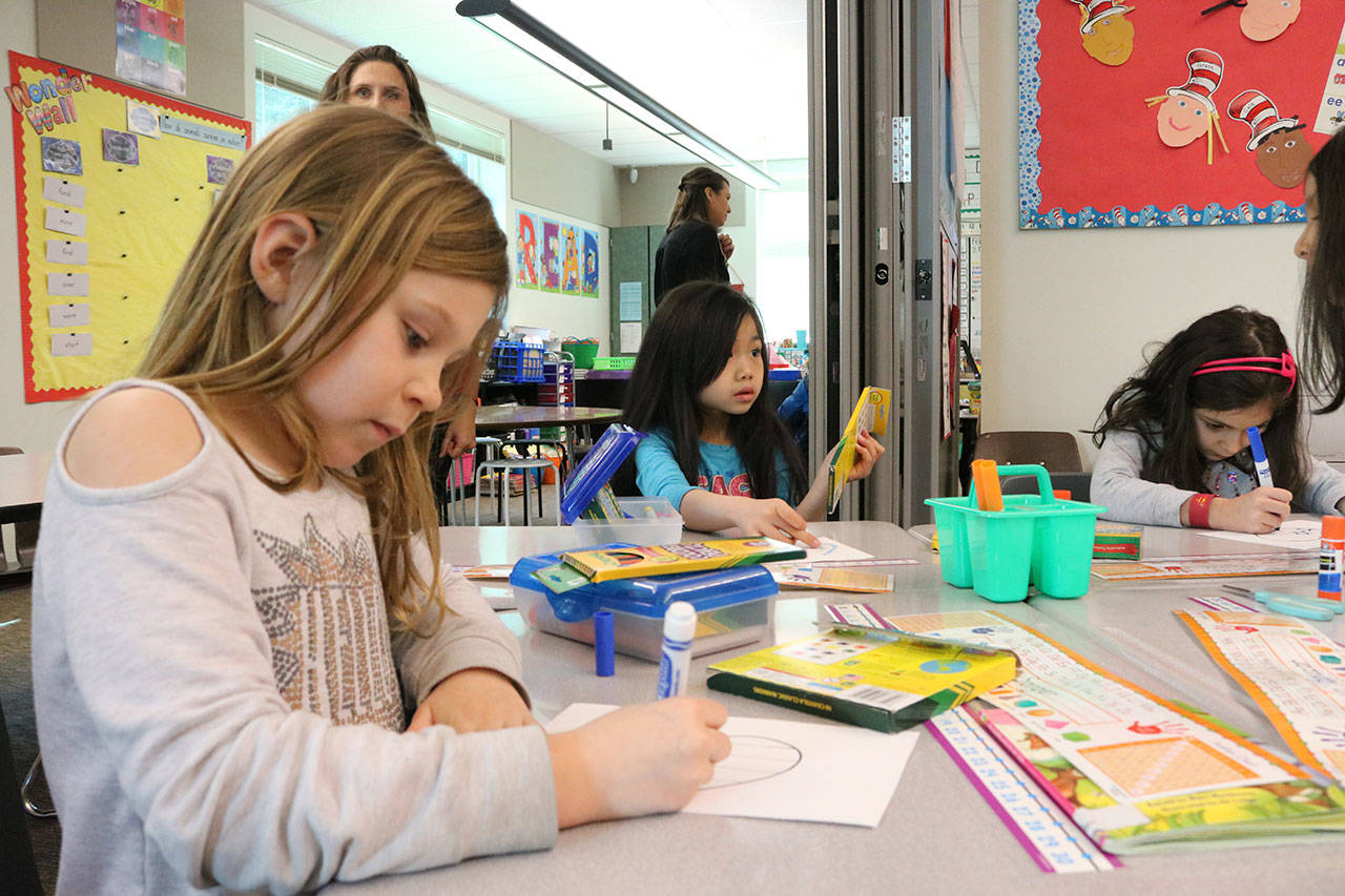 From left, Rose Hill Elementary School first graders Brynley Songer, Anna Nguyen and Camilla Briones create Valentines for veterans.Samantha Pak, Kirkland Reporter