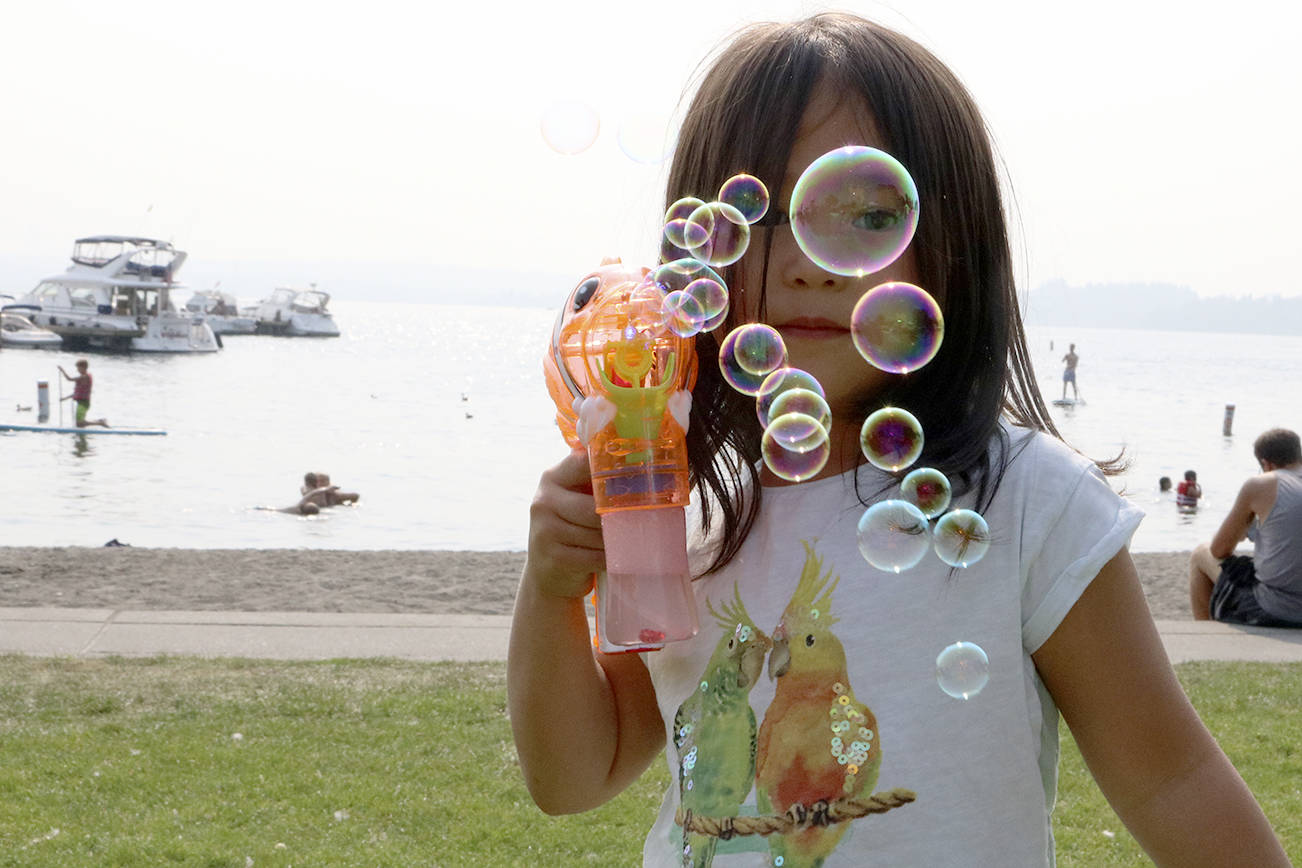 Tia Ekle, 4, plays with her bubble gun during Kirkland’s Summerfest Aug. 11. Megan Campbell/staff photo