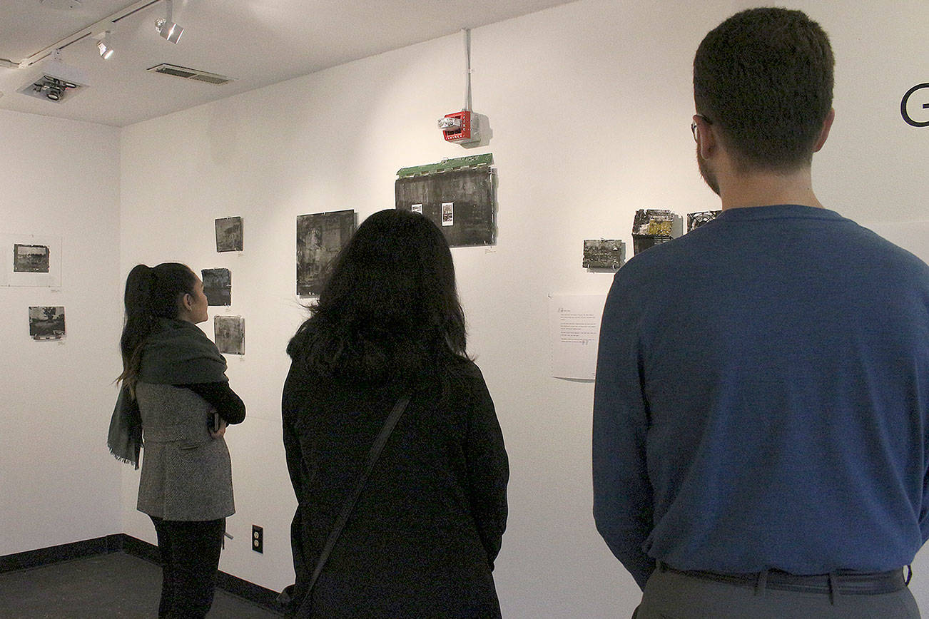 From left: Samantha Areliz (VALA curator), Marisa Mouton Provo (VALA Communication Director) and Zachary Burns (artist) look upon the Gatesville exhibit at the new VALA Eastside in Kirkland. Madison Miller/staff photo.