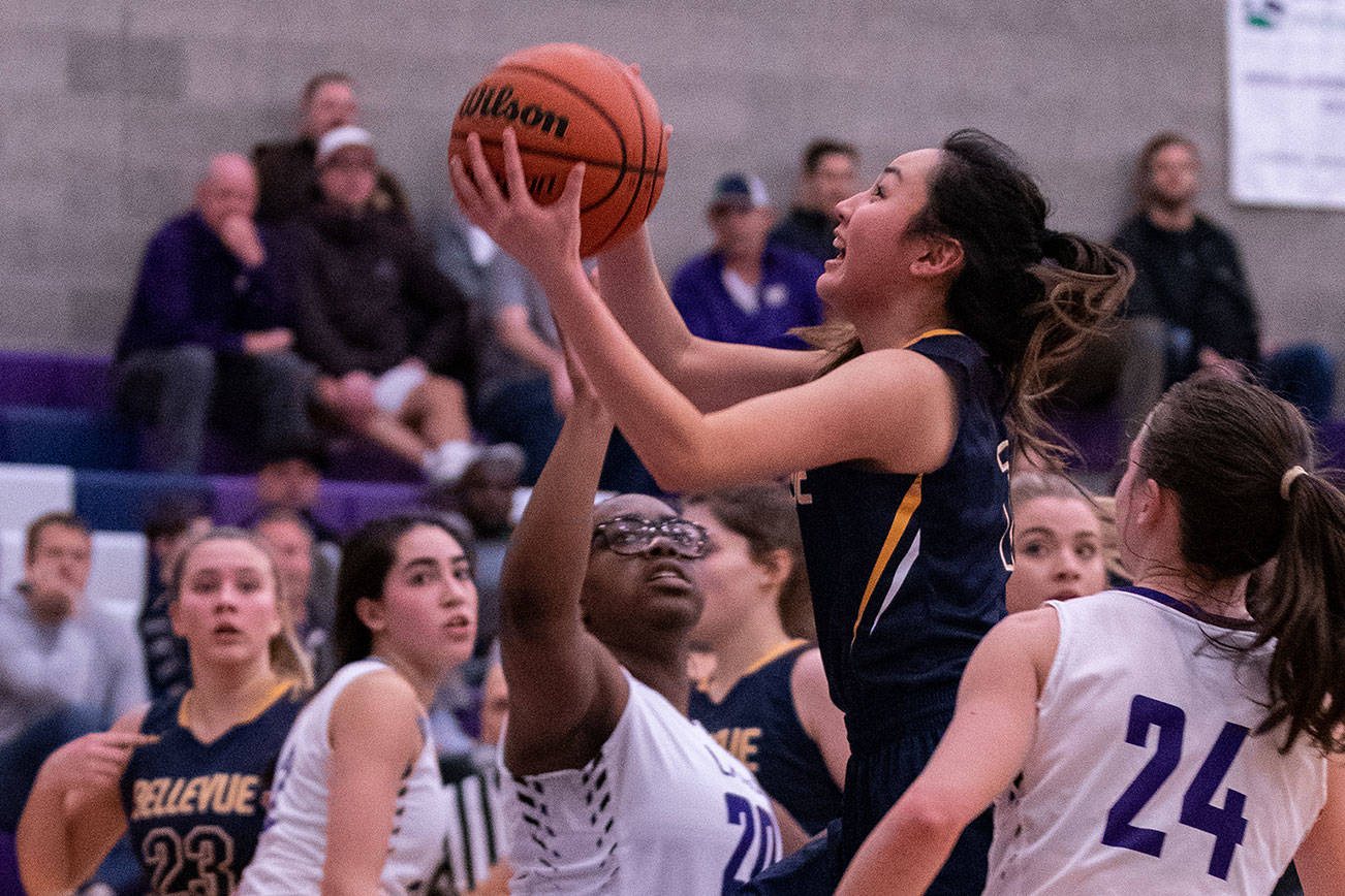Bellevue Wolverines senior guard Kara Choi (pictured) takes the ball to the hoop while being covered by Lake Washington defenders Zaria Opara, left, and Rosa Smith, right, in a 3A KingCo matchup on Jan. 23 in Kirkland. Photo courtesy of Stephanie Ault Justus
