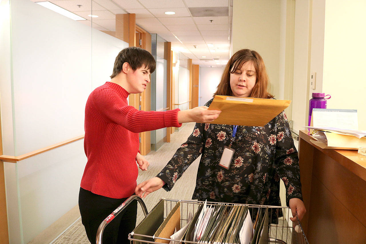 AtWork! employment counselor Emily Lord helps Paige Bisbee navigate around the office with her cart. Bisbee delivers snacks, office supplies, and mail to her co-workers at Davis Wright Tremaine in Bellevue. Stephanie Quiroz/staff photo.