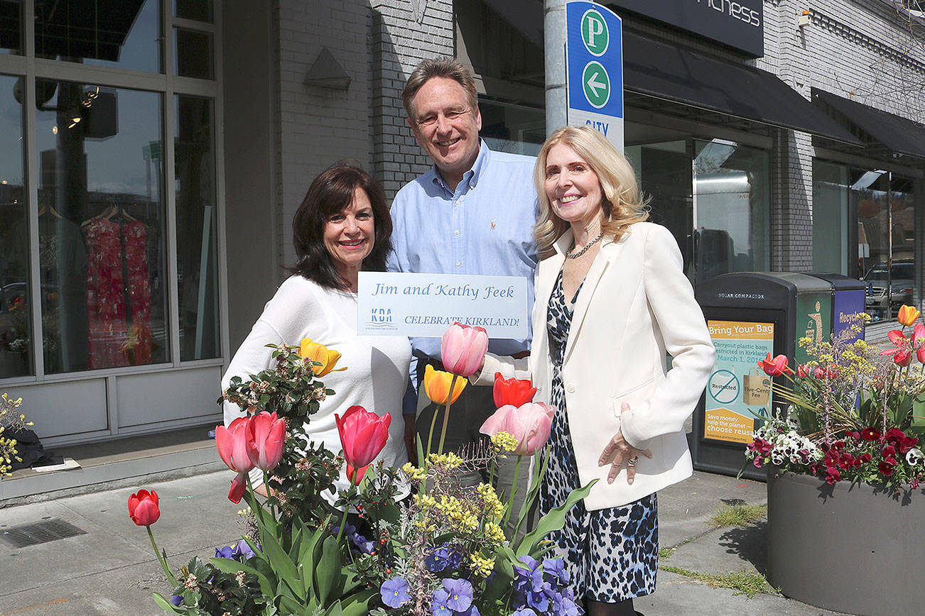 From left: Flower Pot program chair Anne Hess, KDA executive director Michael Friedline, and Flower Pot program chair Kathy Feek pose near flower pots in downtown Kirkland with a sample of the new plaques. Stephanie Quiroz/staff photo.