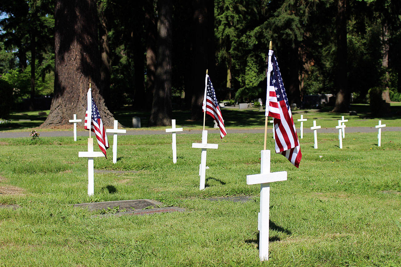 Kirkland volunteers honor local fallen veterans at their graves in the Kirkland Cemetery. White crosses mark each veteran and a U.S. flag commemorates their service. Kailan Manandic / staff photo