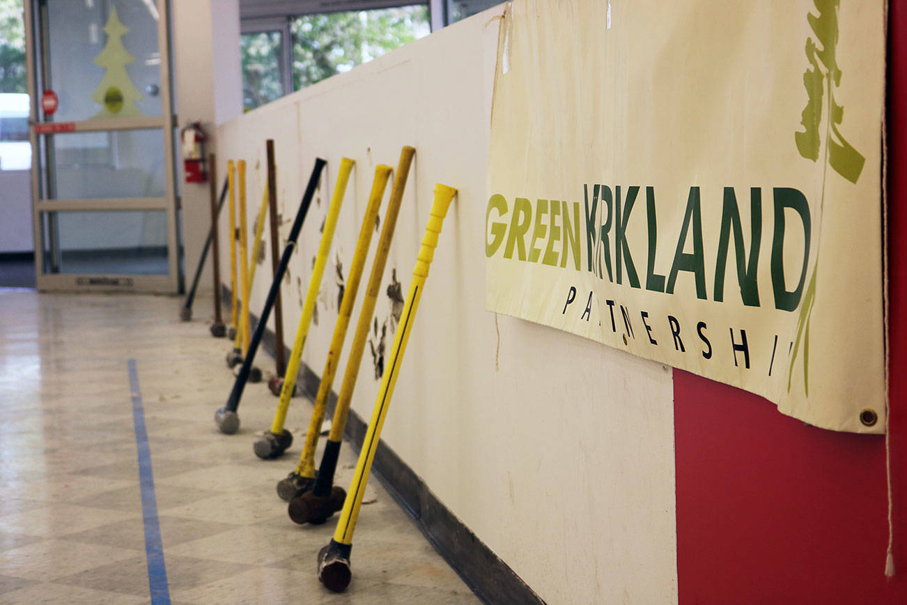 City officials celebrate the new Parks Maintenance Center after slamming sledgehammers against a short wall within the old Office Max building as a way to “break ground” on the renovation project. Kailan Manandic / staff photo