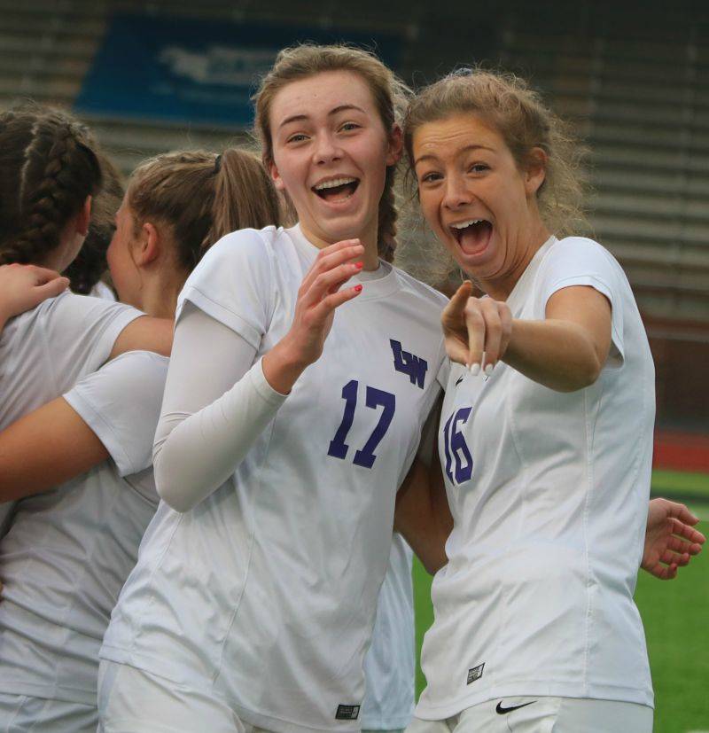 Bella Davis, left, and Emma Eschbach celebrate the Kangs’ state title. Andy Nystrom/ staff photo