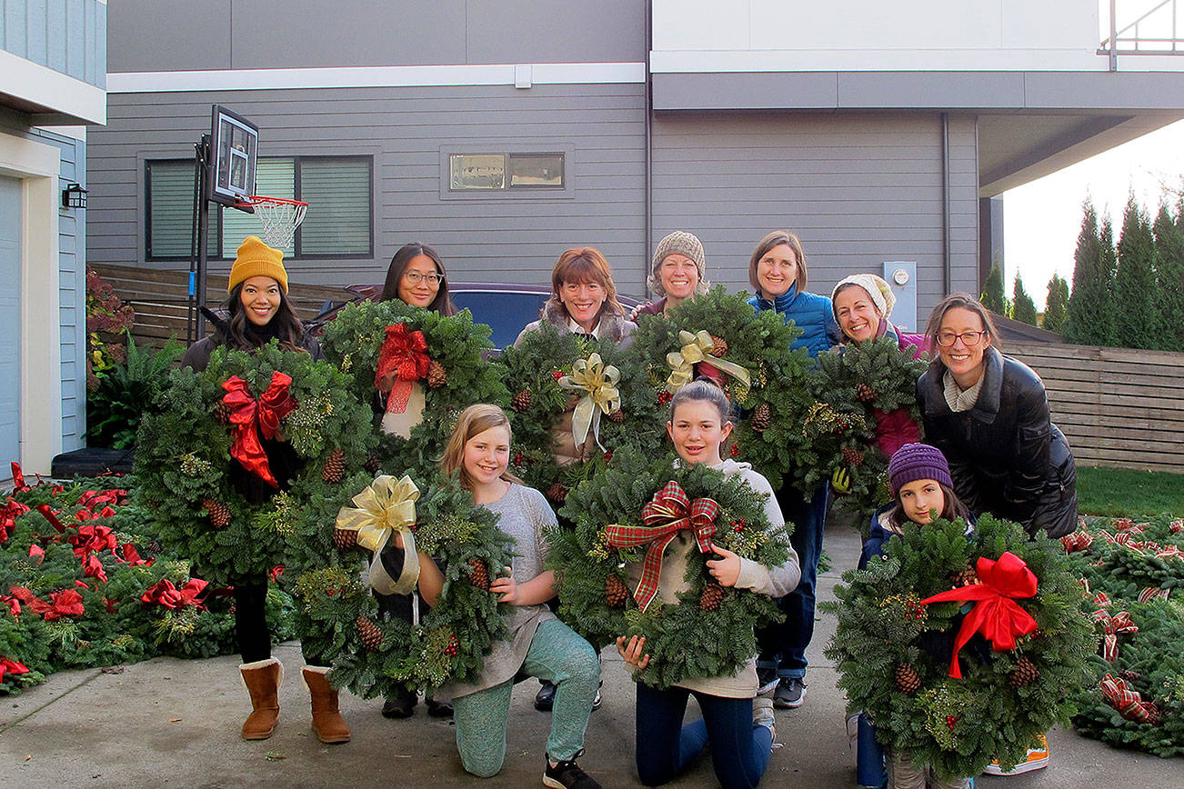 Volunteers from ParentMap join the women of the Terese Smith Howard heritage circle to help tie bows to the wreaths and prepare them for selling. Photo courtesy of Maureen Taasin